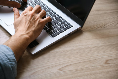 Mans hands typing on laptop keyboard top viewの写真素材