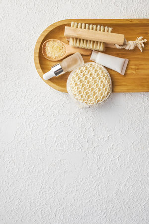 Spa and bathroom accessories on wooden tray, brush, oil, creamの写真素材