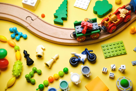 Set of different children's toys, wooden railroad, train, constructor on a yellow background with copy space for text. Top viewの写真素材