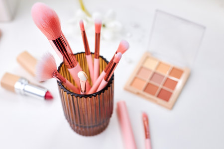 Set of decorative cosmetics on a white table, brushes, eye shadow and lipstick. Decorative cosmetics on dressing table in makeup roomの写真素材