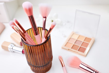 Set of decorative cosmetics on a white table, brushes, eye shadow and lipstick. Decorative cosmetics on dressing table in makeup roomの写真素材