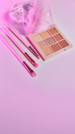 Widescreen background with Set of decorative cosmetics on a white table, brushes and eye shadow. Decorative cosmetics on dressing table in makeup room In pink neon lightの写真素材