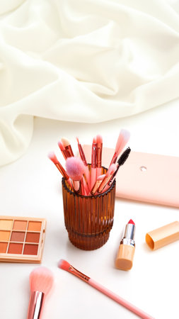 Widescreen background with Set of decorative cosmetics on a white table, brushes and eye shadow. Decorative cosmetics on dressing table in makeup roomの写真素材