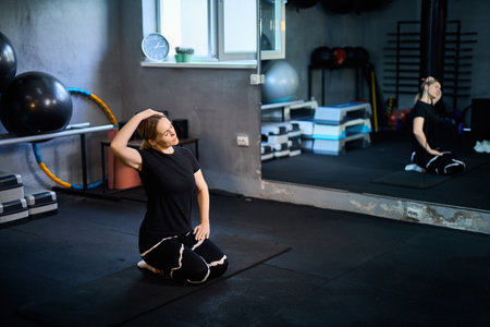 Young attractive sportive woman wearing activewear doing exercises at GYM, working out indoors, healthy active lifestyle conceptの写真素材