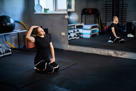 Young attractive sportive woman wearing activewear doing exercises at GYM, working out indoors, healthy active lifestyle conceptの写真素材