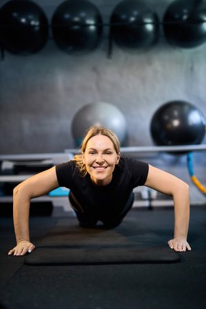 Young attractive sportive woman wearing activewear doing exercises at GYM, working out indoors, healthy active lifestyle conceptの写真素材