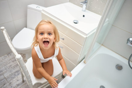 Cheerful, happy little child in the bathroom. Concept of cleanliness, morning chores and happy childhoodの写真素材