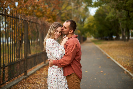 Beautiful and happy couple hugging and smiling while enjoying their time in Autumn Parkの写真素材