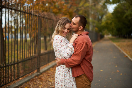 Beautiful and happy couple hugging and smiling while enjoying their time in Autumn Parkの写真素材