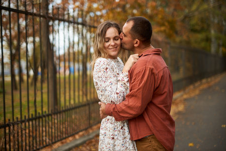 Beautiful and happy couple hugging and smiling while enjoying their time in Autumn Parkの写真素材