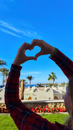 Love gesture against a tropical backdrop. Ideal for romantic, travel, and lifestyle projects.の写真素材