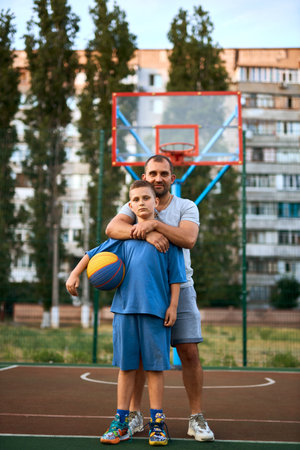 Portrait of happy Father and son after playing basketball together at the basketball court. Sporty lifestyle, training, restの写真素材