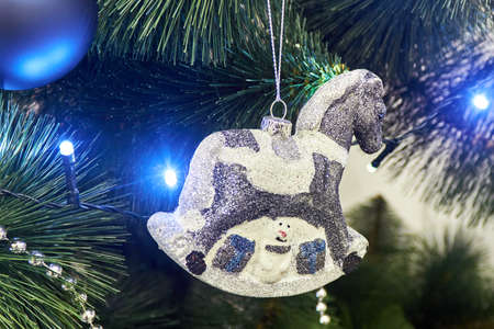 New Year's background. Decorated with toys, balloons, garland Christmas tree. Large toy horse on the Christmas tree.の写真素材