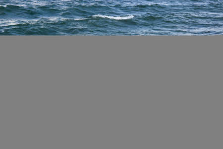 Storm waves at sea. Dark blue sea, waves with bright white sea foam. Abstract natural background.
