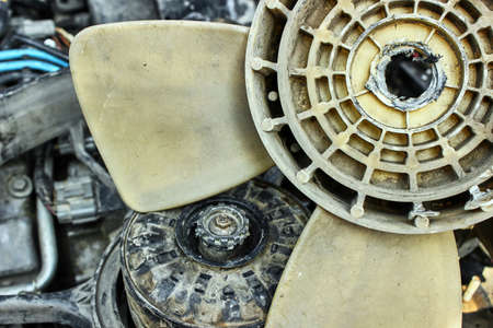 Car engine repair. Urgent repair of a fan malfunction. The old fan of the car broke down, melted in the center. The theme of cars, auto repair shops, repair.の写真素材