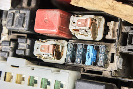 Repair of the fuse box of the car engine by improvised means. Urgent repair of faulty fuses with a coin. The theme of cars, auto repair shops, repair.の写真素材