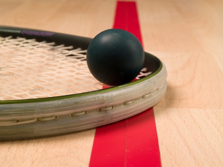 Squash racket and ball next to a red lineの写真素材