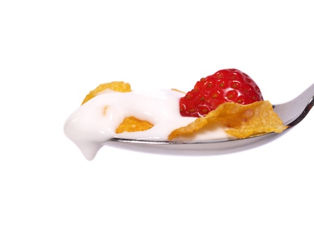Conflakes, strawberries and milk on a spoonの写真素材
