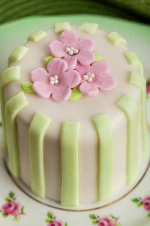 Luxury decorated mini cake with pink petals on a green backgroundの写真素材