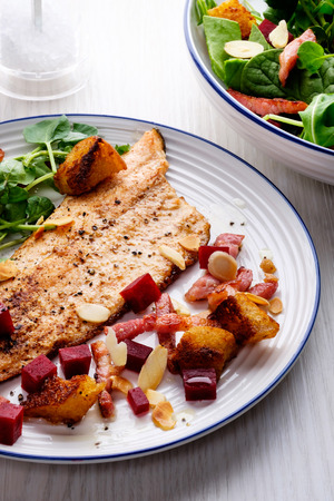 Pan-fried trout with bacon, beetroot and almonds saladの写真素材