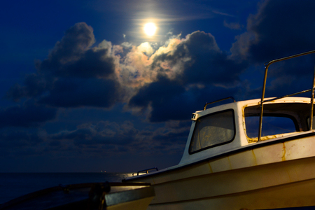 Full Moon Over Small Fishing Boatの写真素材