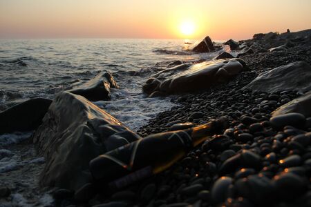A bottle of champagne on the beach at sunsetの写真素材