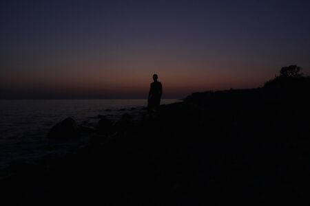 Silhouette of a man at sunset on the beachの写真素材