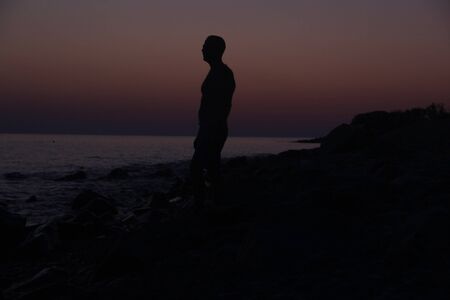 Silhouette of a man at sunset on the beachの写真素材