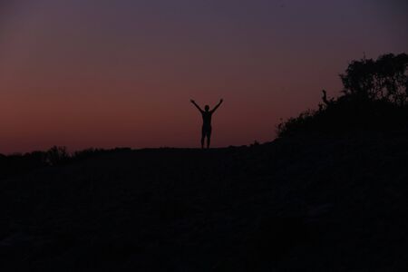 Silhouette of a man at sunset on the beachの写真素材
