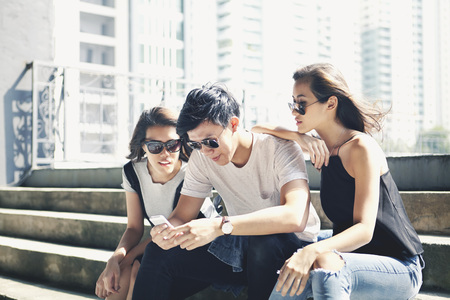 Friends using phone togetherの写真素材