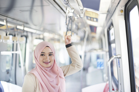 Young Malay Woman holding handle bar in a trainの写真素材