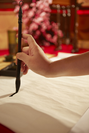 Hand writing Chinese calligraphy with a brush on a sheet of paperの写真素材