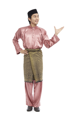 Man in traditional Baju Melayu with hand open to present somethingの写真素材