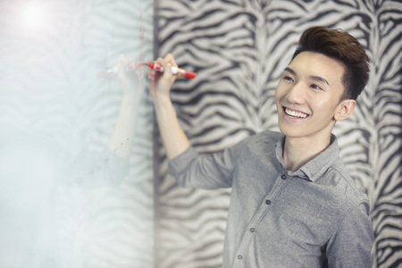 Co-workers writing on whiteboardの写真素材