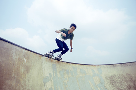 Young man inline skating at a skate parkの写真素材