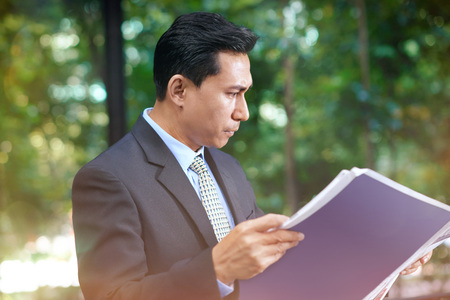 Businessman reading newspaperの写真素材