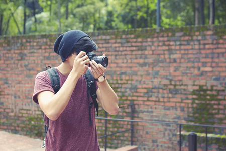 Young man taking pictures at a parkの写真素材