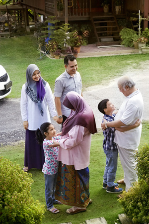 Grandchildren greeting their grandparents while their parents look on