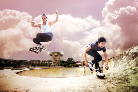 Young men doing inline skating tricks at a skate park