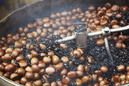 Chestnuts (castanea sativa) being cooked in hot metal potの写真素材