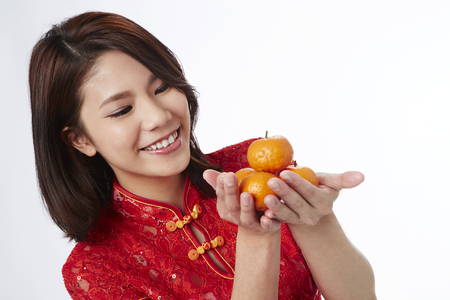 Young woman holding mandarin orangeの写真素材