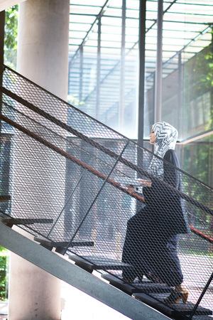 Businesswoman walking up the stairs in officeの写真素材