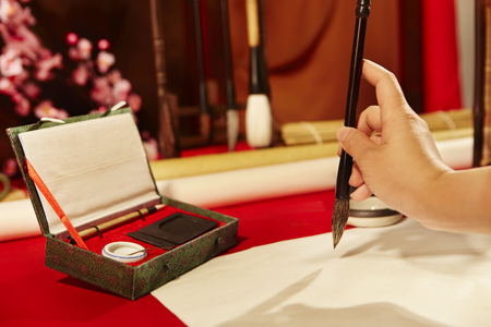 Hand writing Chinese calligraphy with a brush on a sheet of paper