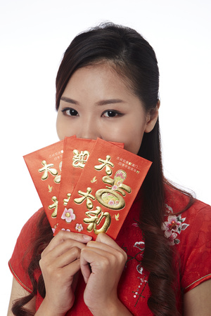 Young woman in traditional Cheongsam holding red envelopeの写真素材