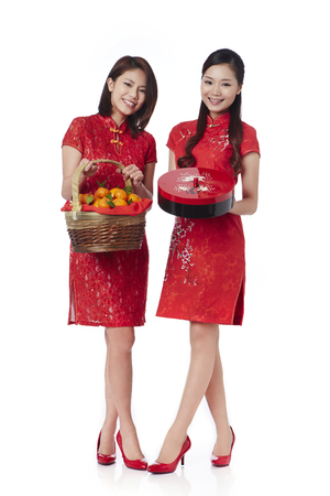 Young women holding gift box and mandarin oranges in a bamboo basketの写真素材