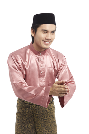 Man in traditional Baju Melayu with hands in Salam greeting gestureの写真素材