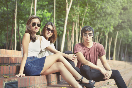 Friends hanging out together while sitting on steps in a parkの写真素材