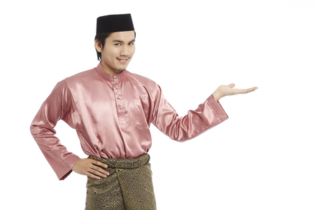 Man in traditional Baju Melayu with hand open to present somethingの写真素材