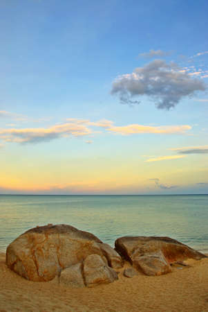 Sunset Beach with Stones in the foregroundの写真素材
