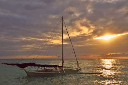 Paradise sunset with outrigged boat